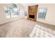 Bright living room featuring a brick fireplace, neutral carpet, and large windows at 1507 Wheeler Rd, Apopka, FL 32703