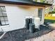 Well water treatment system behind home with dark mulch and access to exterior of house at 1507 Wheeler Rd, Apopka, FL 32703