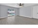 Open living room with sliding doors to the pool, ceiling fan, and light gray luxury vinyl plank flooring at 1913 Poinsetta Ln, Maitland, FL 32751