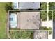 Aerial rooftop view features a backyard pool with screened enclosure, palm trees, and neighboring houses at 8646 La Isla Dr, Kissimmee, FL 34747