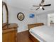 Bedroom features wood flooring, ceiling fan, and dresser with a round mirror above it at 8646 La Isla Dr, Kissimmee, FL 34747