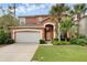 Charming two-story home featuring a two-car garage and lush tropical landscaping at 8646 La Isla Dr, Kissimmee, FL 34747