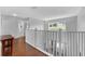 Upstairs hallway offers wood flooring, railing, and a view of the backyard at 8646 La Isla Dr, Kissimmee, FL 34747