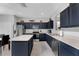 A kitchen with stainless appliances, an island and stylish blue cabinets combines functionality with modern aesthetics at 8646 La Isla Dr, Kissimmee, FL 34747
