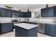 A well-equipped kitchen features an island, stainless steel appliances, and blue cabinets, blending style with functionality at 8646 La Isla Dr, Kissimmee, FL 34747
