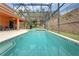 Beautiful screened-in pool area with a pool, jacuzzi, and seating area at 8646 La Isla Dr, Kissimmee, FL 34747