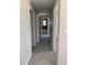 Bright hallway showcasing neutral paint, tile flooring, and several doorways to other rooms at 1 Pecan Course Cir, Ocala, FL 34472