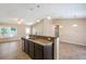 Kitchen island with granite countertop, sink, and seating, and a view into the living room at 1 Pecan Course Cir, Ocala, FL 34472