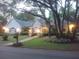 Evening view of single story home featuring landscape lighting and mature trees at 19811 Lake Dorr Rd, Altoona, FL 32702