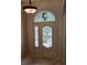 Elegant front door with stained glass in an arched transom and sidelight panels at 19811 Lake Dorr Rd, Altoona, FL 32702