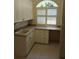 A laundry room features upper and lower white cabinets, light countertops and a window for lots of natural light at 19811 Lake Dorr Rd, Altoona, FL 32702