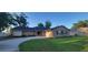 Charming single story home with a brick facade, lush green lawn, and mature trees at 1524 New Jersey Oaks Ct, Lakeland, FL 33801