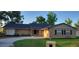 Charming brick home featuring a well-manicured lawn and a driveway leading to a welcoming entrance at 1524 New Jersey Oaks Ct, Lakeland, FL 33801