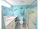 Bright and modern bathroom with light blue walls, a glass-enclosed shower, and marine-themed decor at 3100 Ocean Shore Blvd # 101, Ormond Beach, FL 32176