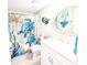 Bathroom with white vanity, decorative mirror and shower with a blue themed shower curtain at 3100 Ocean Shore Blvd # 101, Ormond Beach, FL 32176