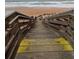 Wooden beach access stairway with caution signs leading down to the sandy shore at 3100 Ocean Shore Blvd # 101, Ormond Beach, FL 32176