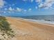 Expansive beach with soft sand, gentle waves, and clear skies at 3100 Ocean Shore Blvd # 101, Ormond Beach, FL 32176