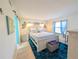 Bedroom with wood-look floors, coastal decor and king bed with turquoise accents at 3100 Ocean Shore Blvd # 101, Ormond Beach, FL 32176