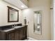 Bathroom with a dark wood vanity, granite top, and framed mirror at 4346 Thomas Wood Ln E, Winter Haven, FL 33880