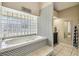 Bathroom featuring a tub with unique patterned tile work and a glass block window at 4346 Thomas Wood Ln E, Winter Haven, FL 33880