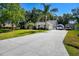 Long driveway leads to a well-maintained home with attached garage, palm trees, and RV parking at 4346 Thomas Wood Ln E, Winter Haven, FL 33880