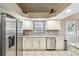 The kitchen features stainless steel appliances, white cabinets, granite counters, and tile flooring at 4346 Thomas Wood Ln E, Winter Haven, FL 33880
