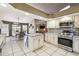 Bright kitchen with white cabinets, granite counters, island, stainless appliances, and tile floors at 4346 Thomas Wood Ln E, Winter Haven, FL 33880