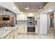 Well-appointed kitchen featuring white cabinets, granite countertops, stainless steel appliances, and tile flooring at 4346 Thomas Wood Ln E, Winter Haven, FL 33880