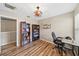 Functional bedroom with wood-look floors, bookshelf, desk, modern ceiling fan, and convenient closet access at 6059 Twain St # 108, Orlando, FL 32835