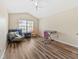 Bright bedroom with vaulted ceiling, wood-look floors, window, ceiling fan, and casual seating area at 6059 Twain St # 108, Orlando, FL 32835