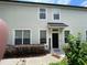 View of the home's exterior with well-maintained landscaping and inviting entrance and dark front door at 6059 Twain St # 108, Orlando, FL 32835