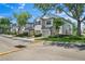 View of townhomes featuring attached garages and landscaped grounds under a bright blue sky at 6059 Twain St # 108, Orlando, FL 32835