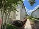 Townhome exterior featuring manicured shrubs, side entry, and landscaped walkway and side yard at 6059 Twain St # 108, Orlando, FL 32835