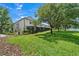 Exterior lawn view of a multi-unit dwelling showcasing meticulously maintained greenery and a tranquil pond at 6059 Twain St # 108, Orlando, FL 32835
