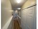 Hallway with wood-look floors and a closet, leading towards the upper level at 6059 Twain St # 108, Orlando, FL 32835