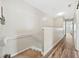 Hallway with hardwood flooring and neutral walls leading to carpeted stairs at 6059 Twain St # 108, Orlando, FL 32835