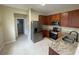 Modern kitchen featuring stainless steel appliances, wood cabinets, and granite countertops at 6059 Twain St # 108, Orlando, FL 32835