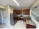Modern kitchen with stainless steel appliances, granite countertops, and dark wood cabinets at 6059 Twain St # 108, Orlando, FL 32835