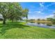 Scenic lake view with lush green lawn and mature trees on a sunny day at 6059 Twain St # 108, Orlando, FL 32835