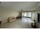 Spacious living room with neutral tones, tile flooring, and sliding glass doors to the lanai at 6059 Twain St # 108, Orlando, FL 32835