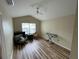 Bright living room featuring wood floors, a ceiling fan, and plenty of natural light from the window at 6059 Twain St # 108, Orlando, FL 32835