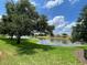 A lush green lawn that meets a pond with a building in the background at 6059 Twain St # 108, Orlando, FL 32835
