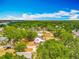 An aerial view highlights a residential area with lush trees, various homes, and distant lake views at 70 N Oak Ave, Umatilla, FL 32784