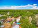 Aerial shot displays property amidst tree-lined neighborhood with pool and nearby community features at 70 N Oak Ave, Umatilla, FL 32784