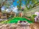 Inviting backyard featuring lush artificial turf, a charming deck, and a cozy brick fire pit at 70 N Oak Ave, Umatilla, FL 32784