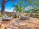 Inviting backyard with a spacious wooden deck, lounge chairs, dining table, and lush landscaping at 70 N Oak Ave, Umatilla, FL 32784