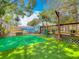 Picturesque backyard with artificial turf, a deck, a pool, and a built-in mini golf at 70 N Oak Ave, Umatilla, FL 32784
