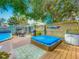Beautiful backyard with a deck, hot tub, pool, patio table, and manicured landscaping at 70 N Oak Ave, Umatilla, FL 32784