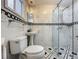 A bathroom view with glass shower, toilet, pedestal sink, and black and white decorative border at 70 N Oak Ave, Umatilla, FL 32784
