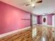 A bedroom view featuring hardwood floors, ceiling fan, and natural light at 70 N Oak Ave, Umatilla, FL 32784